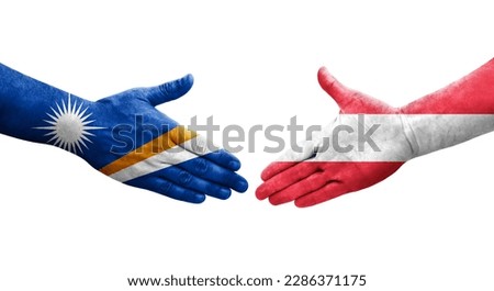 Handshake between Austria and Marshall Islands flags painted on hands, isolated transparent image.