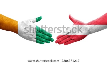 Handshake between Austria and Ivory Coast flags painted on hands, isolated transparent image.