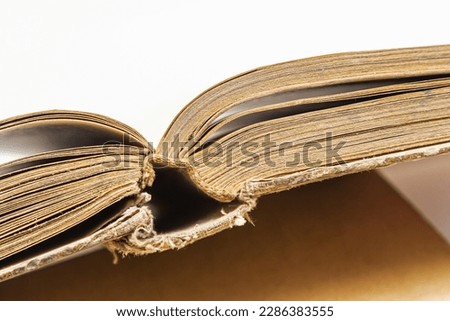 Open old book with text on white background. The concept of reading literature, education and book publishing. Free space for text.