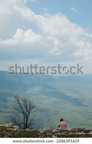 a woman sitting on a mountain beautiful nature hiking journey