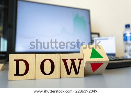 Wooden cubes with the inscription Dow Jones Index and a cube symbolizing the rise and fall of financial markets. Royalty-Free Stock Photo #2286392049