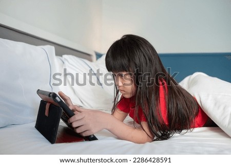 kid watching tablet on the bed, child addicted cartoon

