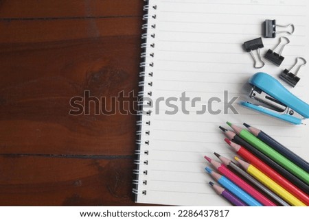 lots of colored pencils and a notepad on the table