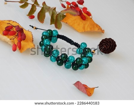 Beautiful green bracelet on a white background. Bead green bracelet and leafs