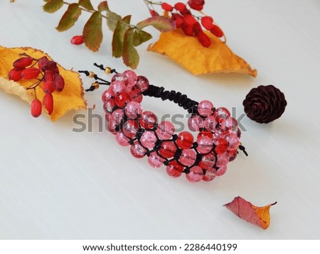 Beautiful pink bracelet on a white. Pink friendship bracelet and leafs