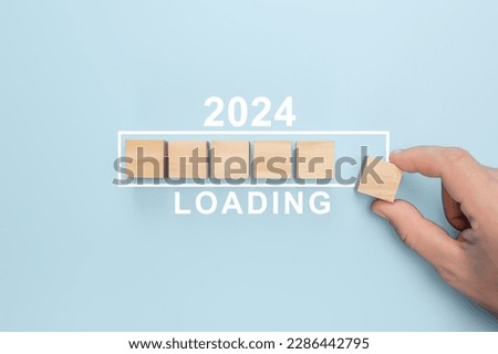 2024 New Year Loading. Loading bar with wooden blocks 2024 on blue background. Start new year 2024 with goal plan, goal concept, action plan, strategy, new year business vision. Royalty-Free Stock Photo #2286442795