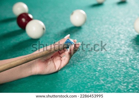 Caucasian young girl playing billiards.