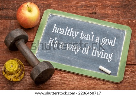 Healthy is not a goal, it is a way of living advice or reminder - note on a slate blackboard with a dumbbell, apple and tape measure, fitness and personal development concept Royalty-Free Stock Photo #2286468717