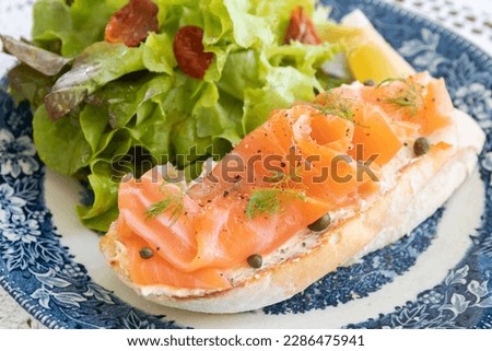 Smoked salmon with cream cheese on french Baguette and fresh salad.