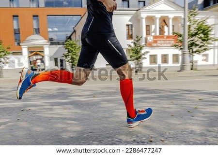 athlete runner in compression socks running city marathon race, sports photos