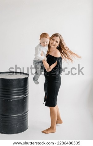 A young happy mother embraces child son isolated on white background wall in studio. Funny parent hugging children and playing with kid. Mom and son. Closeup photo. Family studio portrait. Royalty-Free Stock Photo #2286480505