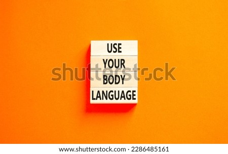 Use your body language symbol. Concept words Use your body language on wooden block. Beautiful orange table orange background. Motivational business Use your body language concept. Copy space.