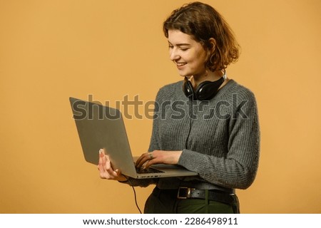 Portrait of intelligent cheerful lady skilled executive assistant holding in hand laptop working remotely isolated bright beige color background