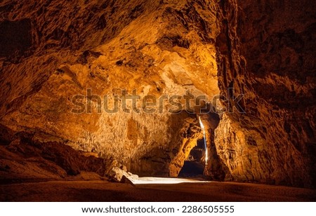 Sunlight in a mountain cave. Mountain cave tunnel. Beautiful sunlight in cave. Cave hole landscape Royalty-Free Stock Photo #2286505555