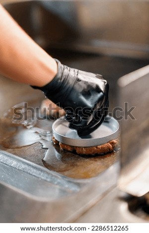 The chef in the kitchen of restaurant makes cutlets for hamburgers smash burger beefsteak Royalty-Free Stock Photo #2286512265