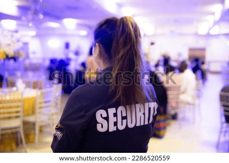 Female security guard protecting an entrance of a private cultural dance event Royalty-Free Stock Photo #2286520559