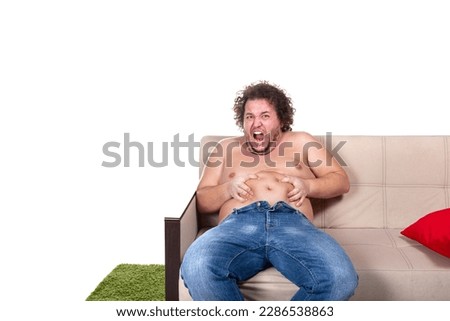 Funny fat man is sitting on the couch. Diet and healthy lifestyle. Royalty-Free Stock Photo #2286538863