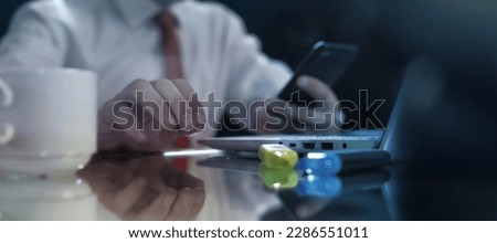 Businessman with a smartphone in his hand at the office table.