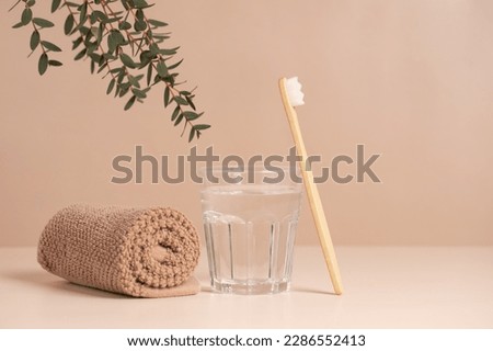 Bamboo toothbrush, towel and a glass of water. Eco-friendly items. Oral care. Biodegradable personal care products. Royalty-Free Stock Photo #2286552413