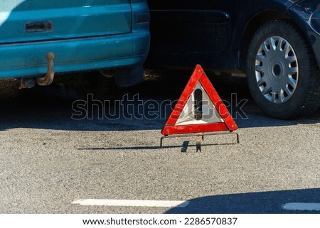 Car accident. A broken-down passenger car is on the road after an accident. Road sign of an emergency stop. Accident insurance on the road.