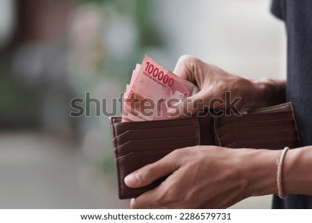 Hands taking out money from wallet Concept of savings, salary, payment and funds Royalty-Free Stock Photo #2286579731