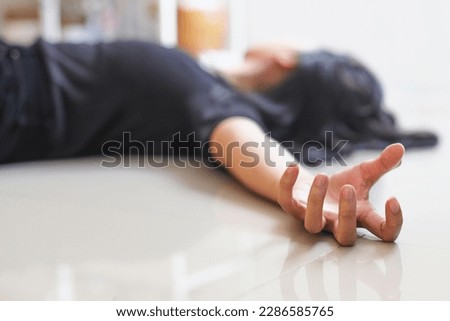 Close-up of hand with epileptic seizures at home against blurred background of fainted woman Royalty-Free Stock Photo #2286585765