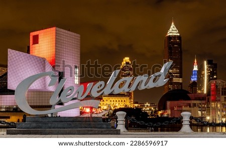 Night view of Cleveland cityscape at night with Cleveland sign and illuminated buildings in the background