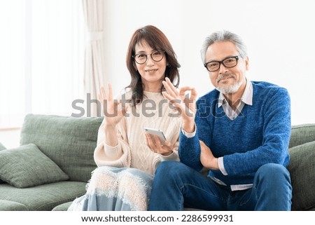 asian senior age couple using a smart phone