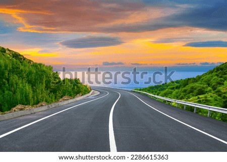 highway landscape at colorful sunset. Road view on the sea. colorful seascape with beautiful road. highway view on ocean beach. coastal road in europe. beautiful nature scenery in the mediterranean. Royalty-Free Stock Photo #2286615363