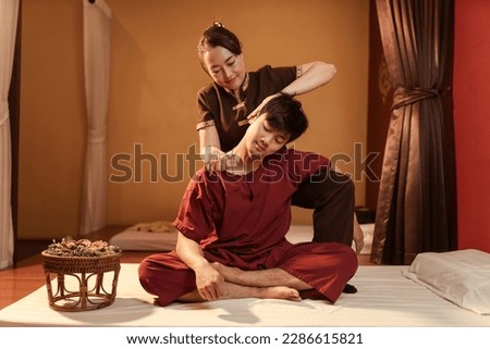 Asian man customer get service thai massage of neck stretching for treat painful from office syndrome with masseur in spa salon. Thai massage with masseur in spa salon. Royalty-Free Stock Photo #2286615821