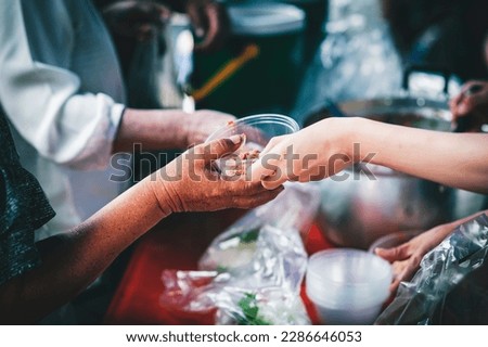 volunteer giving poor homeless bowl of food outdoors : food sharing ideas