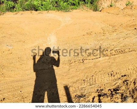 Shadow of a woman taking a picture with a smartphone 
