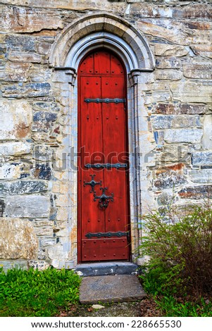 The red door to the medieval stone church