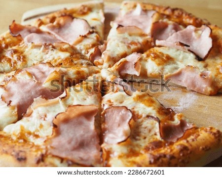 baked and sliced ​​pizza with cheese, ham and sauce. Ready meal