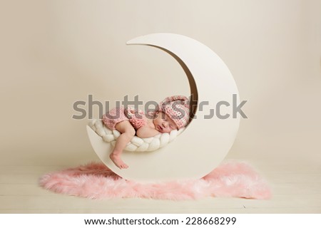 Newborn baby girl sleeping on the moon Royalty-Free Stock Photo #228668299