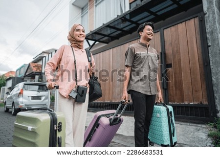 asian muslim couple with suitcase prepare to go. concept of man and woman travelling for eid mubarak celebration Royalty-Free Stock Photo #2286683531