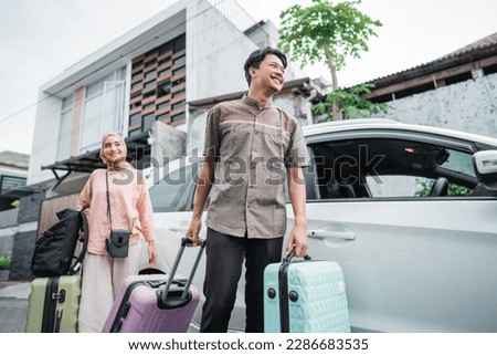asian muslim couple with suitcase prepare to go. concept of man and woman travelling for eid mubarak celebration Royalty-Free Stock Photo #2286683535