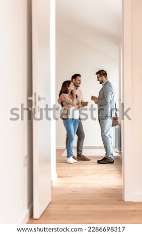 Young married couple talking with a real-estate agent visiting apartment for sale or for rent. Future parents buying an apartment. Real estate concept. A new beginning Royalty-Free Stock Photo #2286698317