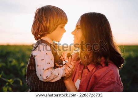 Tender scene of loving son with mom on sunset backdrop. Beautiful family. Cute 3 year old kid with mother. Parenthood, childhood, happiness, children wellbeing concept. High quality photo Royalty-Free Stock Photo #2286726735