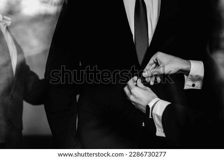 Closeup of groomsmen helping groom to get ready for the wedding ceremony. Royalty-Free Stock Photo #2286730277