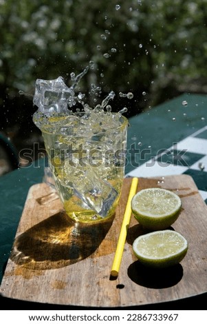  ice falling into lemonade glass                          