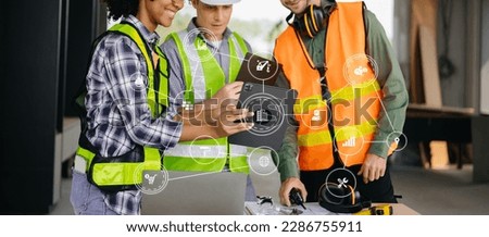 three colleagues discussing data working and tablet, laptop with on on architectural project at construction site at desk in office
