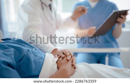 doctor talking with man patient for monitoring and check up after surgery. doctor touching patient hand and consoling. Royalty-Free Stock Photo #2286763359