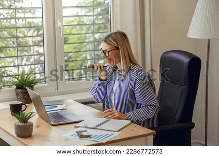 Businesswoman accountant recording audio message to colleagues during work day from home office