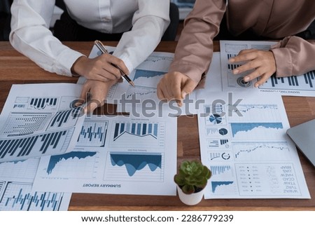Closeup analyst team colleagues discuss financial data on digital dashboard, analyzing charts and graph with supportive teamwork. Professional office use BI to plan marketing business. Enthusiastic