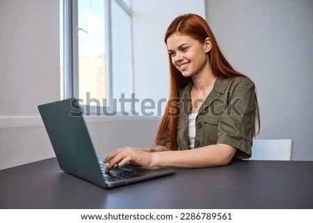 portrait of a happy, joyful woman sitting at a laptop and working in the office