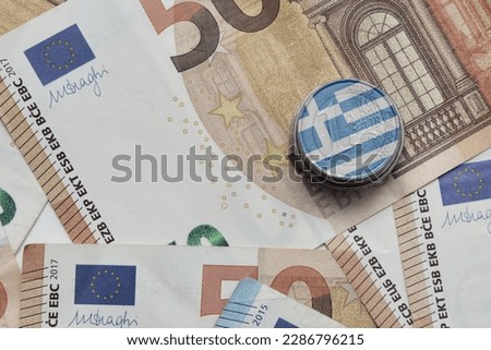 euro coin with national flag of greece on the euro money banknotes background