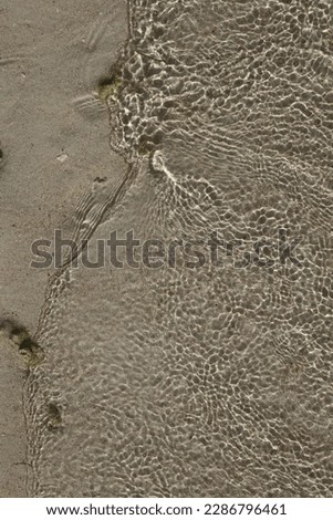 background of clear sea water with brown sand grains Royalty-Free Stock Photo #2286796461