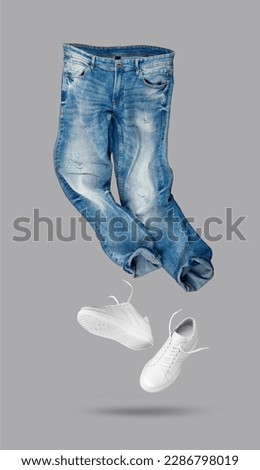 Blue jeans, white leather sneakers isolated on gray background. Branding clothes. Mock up for your design. With clipping path.