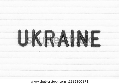 Black color letter in word ukraine on white felt board background